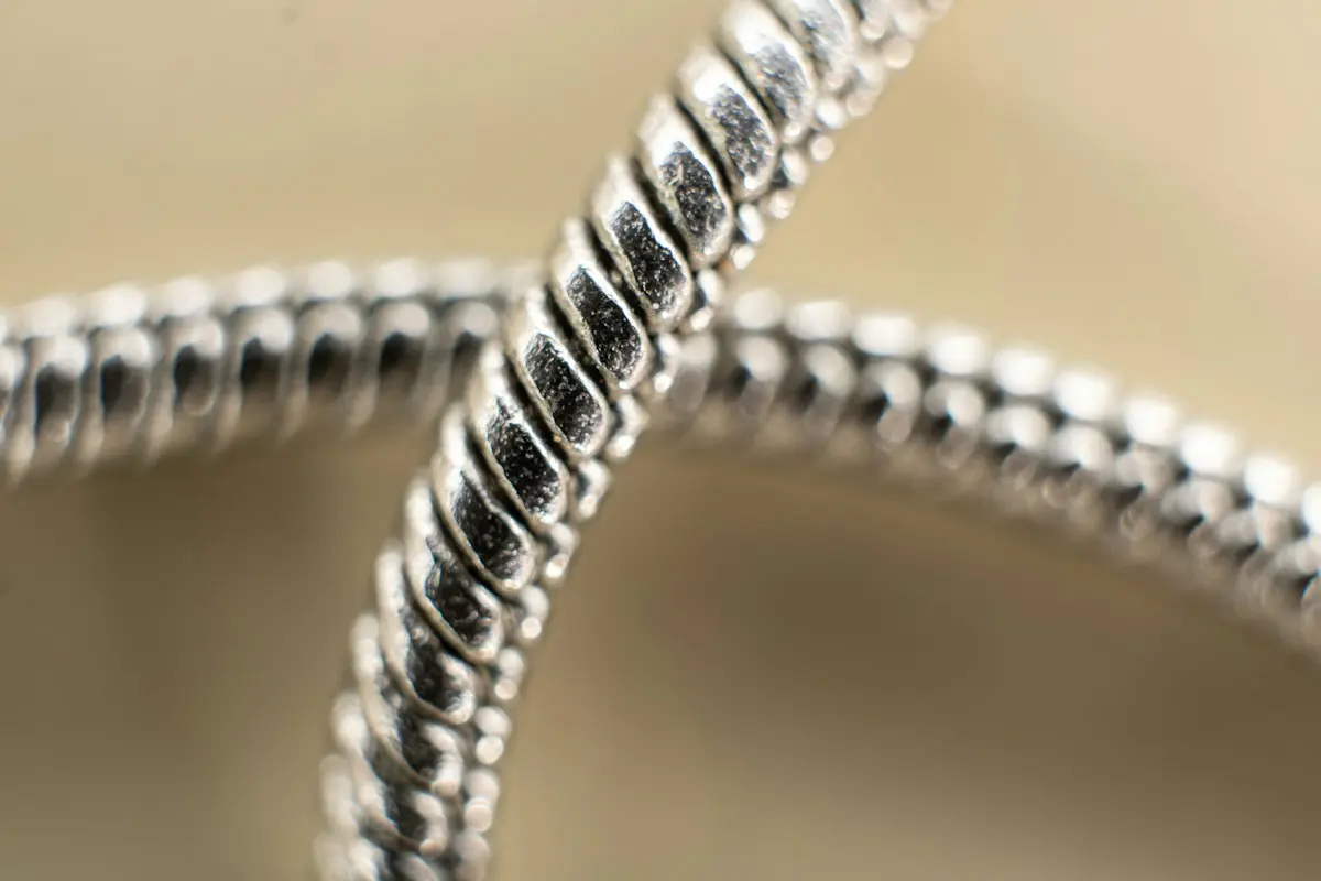 Primer plano de los eslabones de una cadena de plata: el brillo blanco frío de la plata de ley