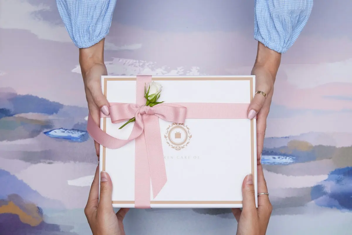 Entrega con firma Dos manos entregando una caja de regalo: así llega una joya comprada online con firma a la entrega
